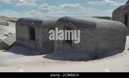 Sinistre regard sur le bunker allemand de la Seconde Guerre mondiale dans les dunes De l'Atlantikwall contre un ciel nuageux Banque D'Images