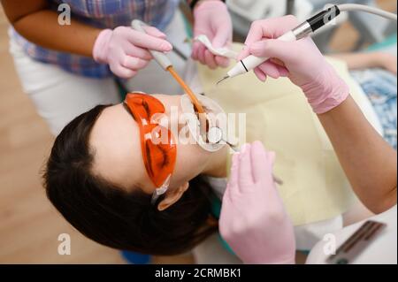 Le dentiste et l'assistant traitent le patient en clinique Banque D'Images