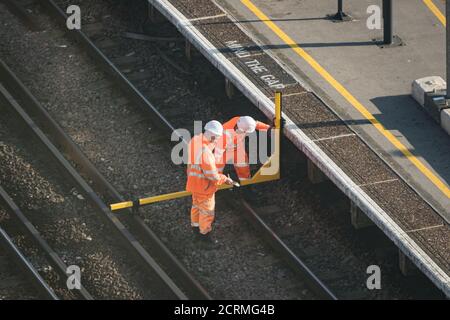 Travailleurs ferroviaires utilisant un appareil de mesure de profil de jauge de chargement Banque D'Images