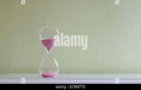 Sablez le verre sur la table à côté du lit. Mesure du temps passant, compte à rebours ou concept de routine quotidienne. Banque D'Images