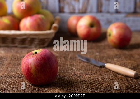 Pommes mûres sur toile de jute et dans un panier. Style rustique, gros plan. Banque D'Images