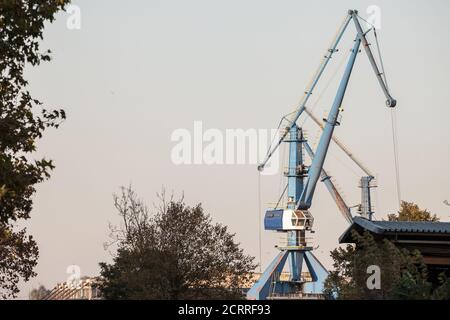 Grues portuaires sur un terminal portuaire fluvial et maritime des Balkans, utilisées pour charger et décharger des conteneurs et autres marchandises dans le cadre des opérations d'importation et d'exportation sur les navires A. Banque D'Images