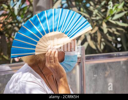 Las Palmas, Grande Canarie, Îles Canaries, Espagne. 20 septembre 2020. Une femme portant un visage recouvrant son visage ombre avec un ventilateur alors qu'elle regarde sur la plage de la ville de Las Palmas sur Gran Canaria sous un soleil glorieux. La pointe actuelle des cas de coronavirus en Espagne et aux îles canaries a vu le Royaume-Uni et l'Allemagne mettre l'Espagne et les îles Canaries sur leur liste de quarantaine. La majeure partie des nouvelles infections sur Gran Canaria se trouvent dans la capitale, Las Palmas. Crédit : Alan Dawson/Alay Live News Banque D'Images