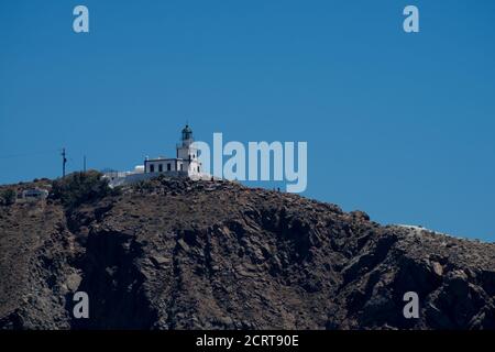 Falaise et phare au sud de l'île de Thira dans les îles grecques, par une journée claire et ensoleillée avec un ciel bleu et lumineux. Akrotiri, Santorin, Grèce. Akroti Banque D'Images