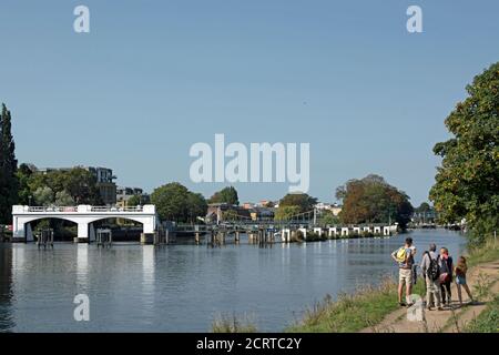 groupe de famille regarde vers teddington weir et teddington pont sur la tamise à ham, surrey, angleterre Banque D'Images