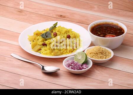 Aloo/Kanda Poha ou Tarri Pohe avec masala/cari épicé. Servi dans une assiette en céramique. Banque D'Images
