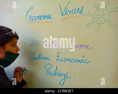 DISTRICT KATNI, INDE - LE 17 MAI 2020 : un enseignant indien a présenté un paquet de 20 roupies de crore lakh pour le soulagement de l'impact du coronavirus sur l'usure légère des panneaux de couleur Banque D'Images