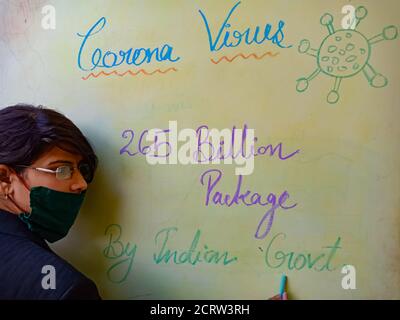 DISTRICT KATNI, INDE - LE 17 MAI 2020 : un enseignant indien a présenté un paquet de 265 milliards de poupées de secours pour l'impact du coronavirus sur le porteur de panneaux de couleur claire Banque D'Images