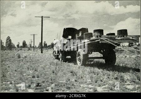 . Magazine de téléphone Bell . Pole Hole Digger faire sa propre tempête de poussière en allant bien entre Moriarty et Santa Rosa, Nouveau-Mexique. WotTND UX HlUll liAlb, illL WUvLS AKL PaVLU Uli i Kum UN rack DE chapeau MOTORISÉ QUE LE LiXEMEN avance à travers le pays à travers la forêt nationale de Cibola. Banque D'Images