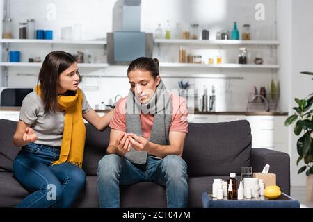 inquiète femme touchant un petit ami malade regardant le thermomètre dans la cuisine Banque D'Images