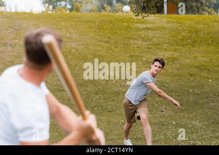 objectif sélectif de l'adolescent qui lance le ballon tout en jouant au baseball avec le père Banque D'Images