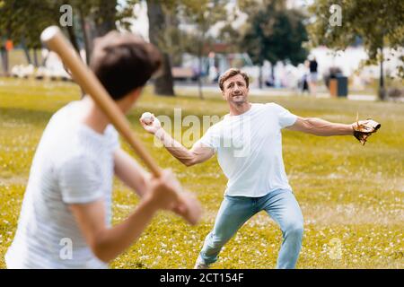 mise au point sélective du père dans le cuir gant tenant le ballon et jouer au baseball avec son fils dans le parc Banque D'Images