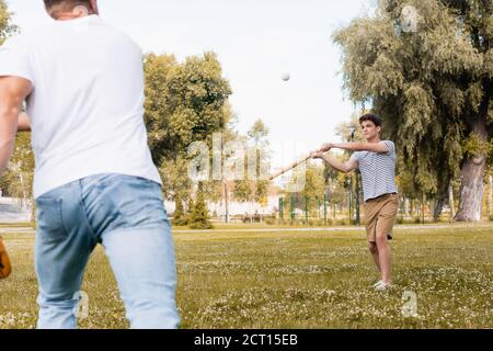 foyer sélectif de fils adolescents avec batte de softball regardant jouez au baseball avec votre père dans le parc Banque D'Images