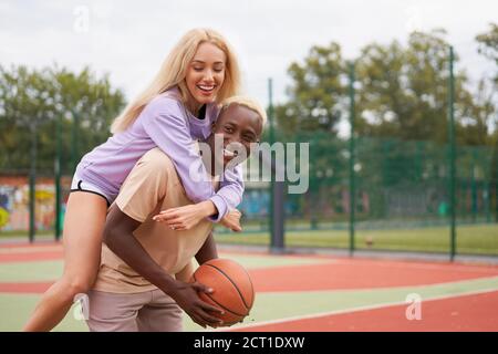 Basket-ball à dos de pigeon afro américain homme amis formation caucasienne Femme amitié multiraciale afro Guy instructeur enseignant amateurs femelle Heal Banque D'Images