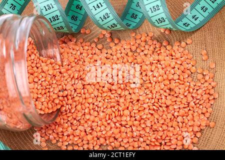 Tas de lentilles rouges organiques et mètre ruban. Banque D'Images