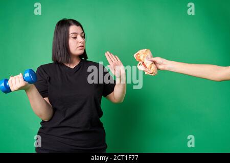 Gras la jeune femme refuse la nourriture de mauvaise qualité. Banque D'Images