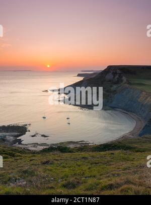 Worth Matravers, Dorset, Royaume-Uni. 20 septembre 2020. Météo Royaume-Uni. Le ciel brille d'orange au coucher du soleil au-dessus de Chapmans Pool et les falaises de Houns Tout sur la côte jurassique près de Worth Matravers à Dorset pendant les derniers jours de la vague de chaleur d'automne avant que le temps ne soit prévu pour se refroidir. Crédit photo : Graham Hunt/Alamy Live News Banque D'Images