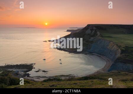 Worth Matravers, Dorset, Royaume-Uni. 20 septembre 2020. Météo Royaume-Uni. Le ciel brille d'orange au coucher du soleil au-dessus de Chapmans Pool et les falaises de Houns Tout sur la côte jurassique près de Worth Matravers à Dorset pendant les derniers jours de la vague de chaleur d'automne avant que le temps ne soit prévu pour se refroidir. Crédit photo : Graham Hunt/Alamy Live News Banque D'Images