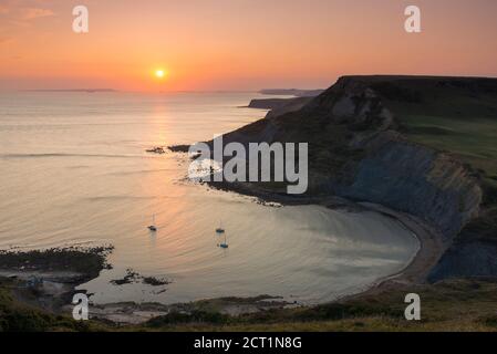 Worth Matravers, Dorset, Royaume-Uni. 20 septembre 2020. Météo Royaume-Uni. Le ciel brille d'orange au coucher du soleil au-dessus de Chapmans Pool et les falaises de Houns Tout sur la côte jurassique près de Worth Matravers à Dorset pendant les derniers jours de la vague de chaleur d'automne avant que le temps ne soit prévu pour se refroidir. Crédit photo : Graham Hunt/Alamy Live News Banque D'Images