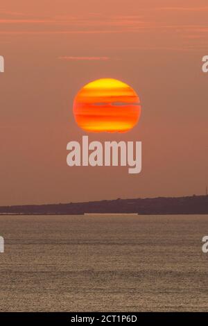 Worth Matravers, Dorset, Royaume-Uni. 20 septembre 2020. Météo Royaume-Uni. Vue sur le coucher du soleil depuis le South West Coast Path à proximité de Worth Matravers à Dorset tandis que le soleil se couche dans la brume orange sur la baie de Weymouth au cours des derniers jours de la vague de chaleur d'automne avant que le temps ne soit prévu pour se refroidir. Crédit photo : Graham Hunt/Alamy Live News Banque D'Images