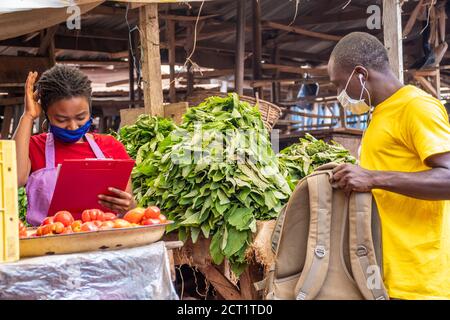 le préposé à la livraison prend un colis d'un africain local négociant de marché Banque D'Images