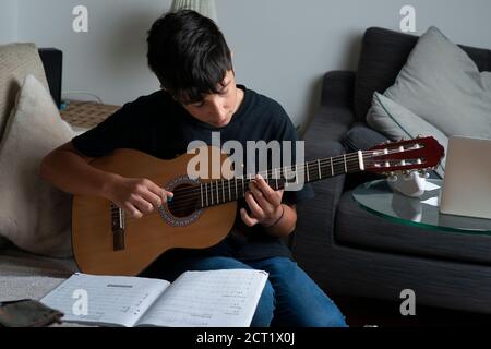 Adolescent, 13 ans, jouant de la guitare classique Banque D'Images