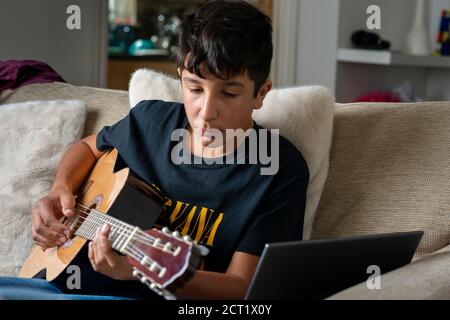 Adolescent, 13 ans, jouant de la guitare acoustique- focus sélectif Banque D'Images