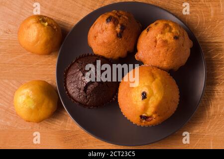 Petits gâteaux et pop-corn dans une assiette noire sur un bois carte Banque D'Images