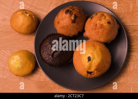 Petits gâteaux et pop-corn dans une assiette noire sur un bois carte Banque D'Images