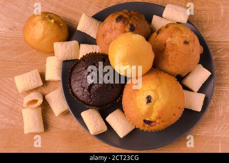 Petits gâteaux et pop-corn dans une assiette noire sur un bois carte Banque D'Images