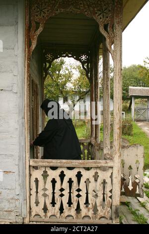 Monastère d'Agafton, comté de Botosani, Roumanie. Une nonne ouvrant la porte de l'église en bois du XVIIIe siècle. Banque D'Images