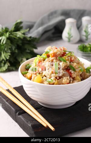 Riz frit avec légumes, ail, gingembre et oignon vert sur fond gris. Cuisine asiatique. Plats végétariens Banque D'Images