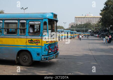 Kolkata, Inde - 1er février 2020 : plusieurs personnes non identifiées passent devant les bus publics traditionnels turquoise et jaune garés à une gare routière Banque D'Images