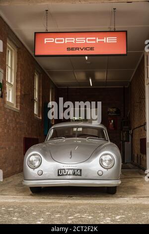 Une Porsche 356 garée dans un garage de service au Bicester Heritage Sunday Scramble Banque D'Images