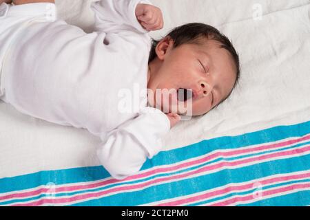 10 jour nouveau-né bébé fille sur le dos réflexe bât gros plan allongé sur la couverture de réception Banque D'Images