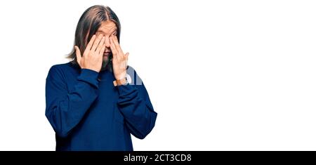 Beau caucasien homme avec de longs cheveux portant décontracté hiver chandail frotter les yeux pour la fatigue et les maux de tête, l'expression endormi et fatigué. Problème de vision Banque D'Images