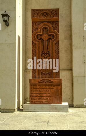 Khachkar de pierre avec la figure de la vierge et de l'enfant, un symbole rond de l'éternité du soleil, installé sur le côté droit du mur de la cathédrale o Banque D'Images