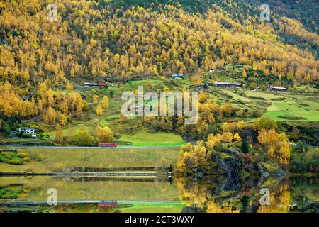 La maison est sur le front de mer de la vallée pendant la saison d'automne. Les feuilles deviennent jaunes toutes les montagnes reflétant la belle eau à la ci Banque D'Images