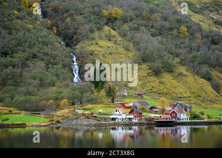 Petit village sur le front de mer et les montagnes en automne qui reflètent l'eau. Regardez au cours d'une excursion en bateau pour découvrir la beauté de Sognefjord Crui Banque D'Images