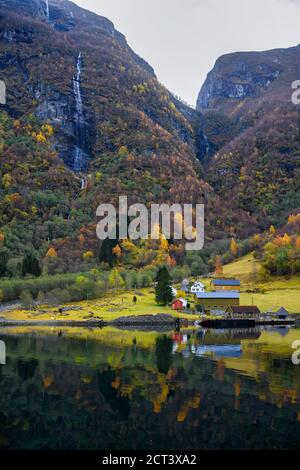 Petit village sur le front de mer et les montagnes en automne qui reflètent l'eau. Regardez au cours d'une excursion en bateau pour découvrir la beauté de Sognefjord Crui Banque D'Images