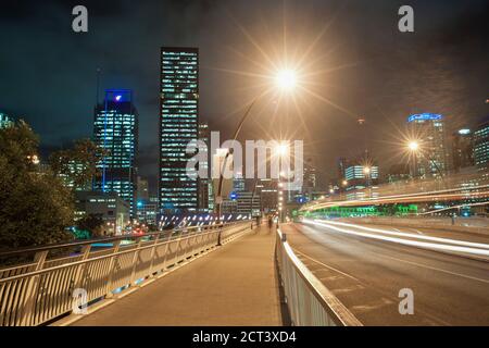 Des sentiers de nuit sur le pont reliant le centre-ville de Brisbane à South Bank, Queensland, Australie Banque D'Images