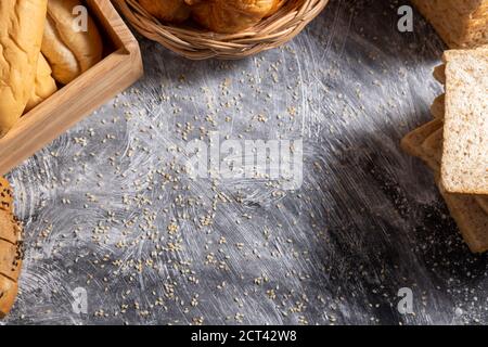 La vue de dessus de la texture de la table noire en bois avec le fond de sésame avec divers petits pains. Banque D'Images