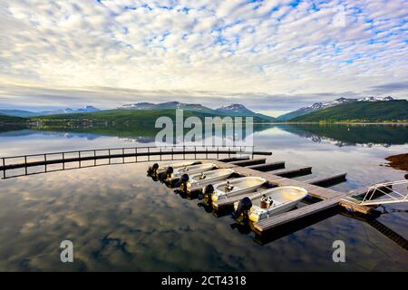 Plusieurs bateaux à moteur sont amarrés dans le port, loués pour la pêche et le voyage, le matin, l'eau miroir-comme lac est à Sorreisa, Norvège, Banque D'Images