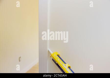 Main d'œuvre appliquant du produit d'étanchéité au silicone avec un pistolet à calfeutrer pour réparer la garniture de moulure de porte Banque D'Images