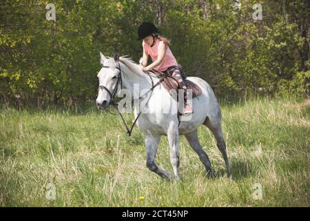 Une petite fille fait du cheval blanc Orlov Trotter Banque D'Images