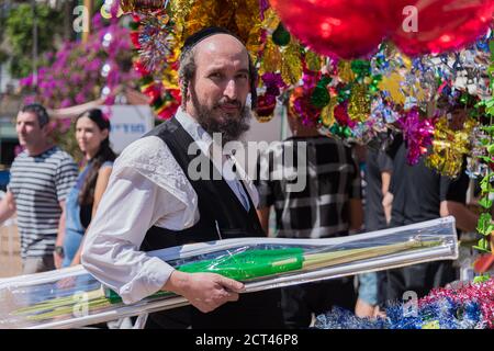 TEL AVIV, ISRAËL – 4 OCTOBRE 2017 : homme juif portant du kippah et tenant une branche de palmier dans le festival des quatre espèces de Sukkot. Décorations de sukkah Banque D'Images