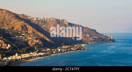 Photo panoramique de la plage de Letojanni et de la plage de Mazzeo et de la mer Ionienne (partie de la mer Méditerranée) vue de Taormine au coucher du soleil, côte est de la Sicile, Italie, Europe Banque D'Images