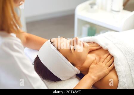 Femme patient obtenant un massage relaxant et rajeunissant manuel pour le visage et épaules du thérapeute Banque D'Images