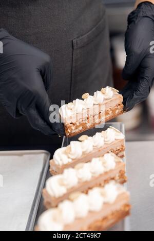 Le chef pâtissier tient des pinces à noix et décorera les gâteaux avant de servir au restaurant. Concept de haute cuisine Banque D'Images