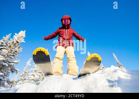 Le skieur prépare le saut, l'angle inférieur du ski, la forêt d'hiver du ciel bleu Banque D'Images